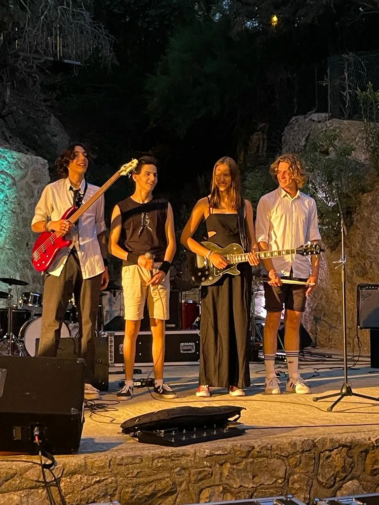 The four members of Kairos on an open-air stage at night, instruments in hand