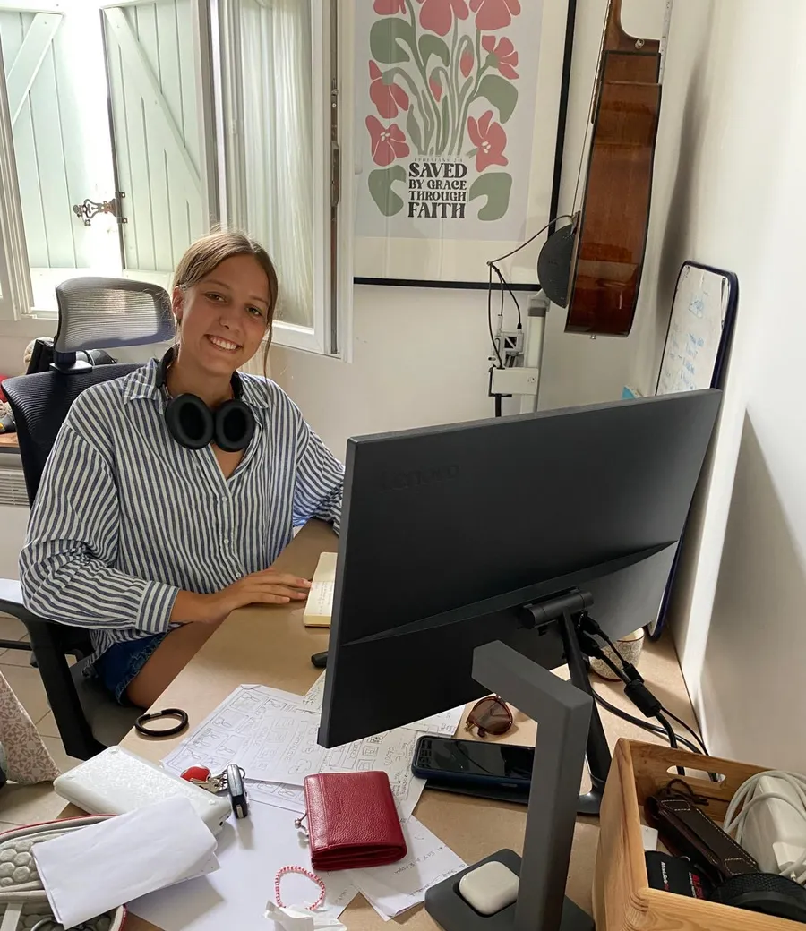 Souriante à mon bureau, casque autour du cou, après la mise en production du pipeline