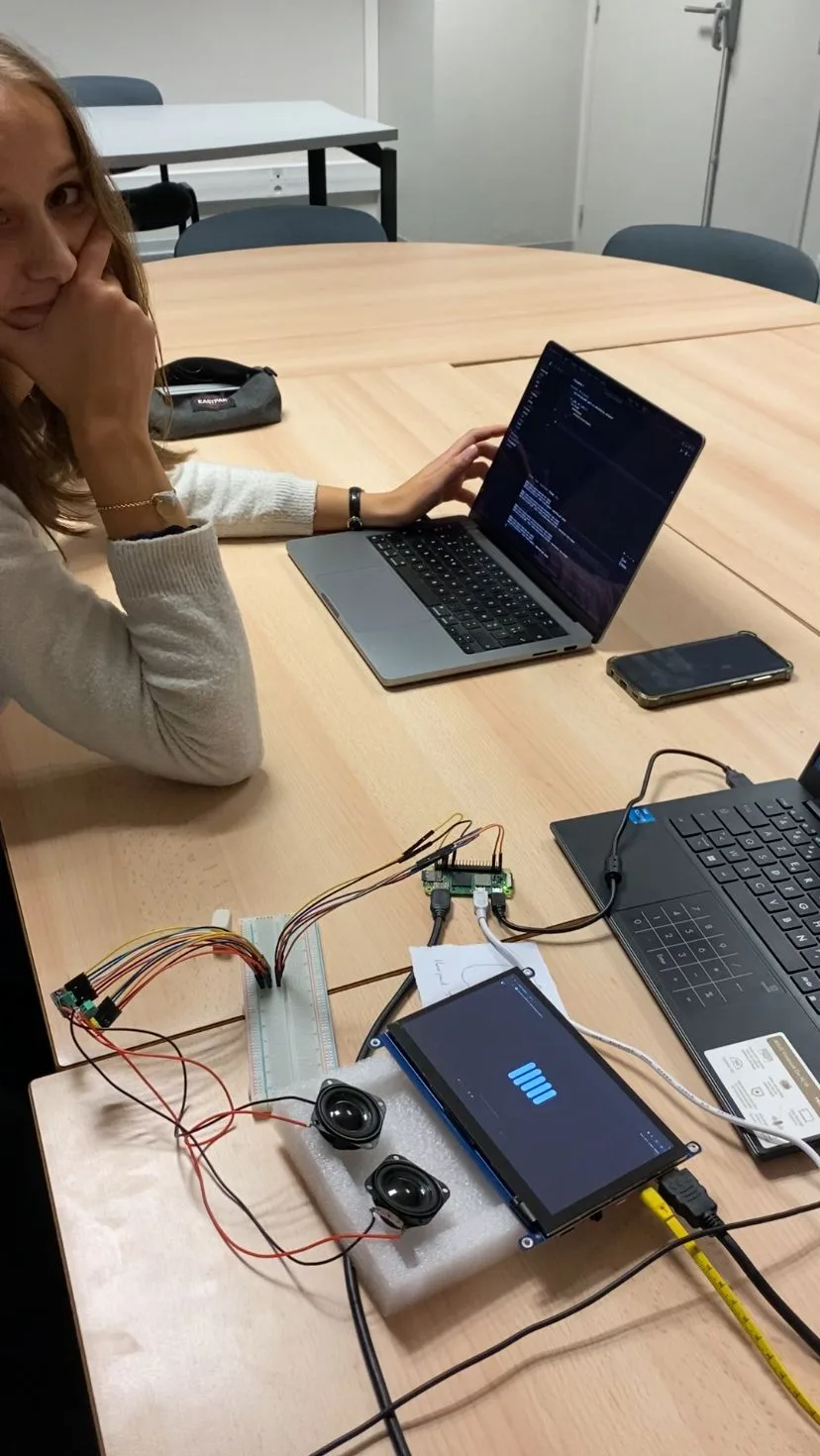 Leaning on the table, looking very pleased, next to the first working Orion build: Raspberry Pi, speakers and a lit-up screen