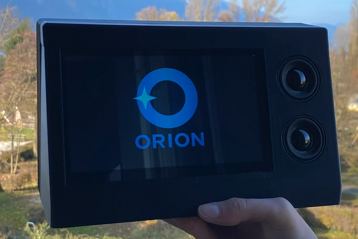 The Orion terminal held in hand outdoors, its logo on the screen